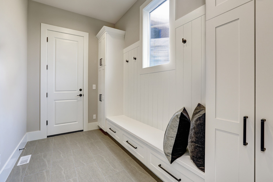 Bright mudroom with stylish white panel door and built-in storage
