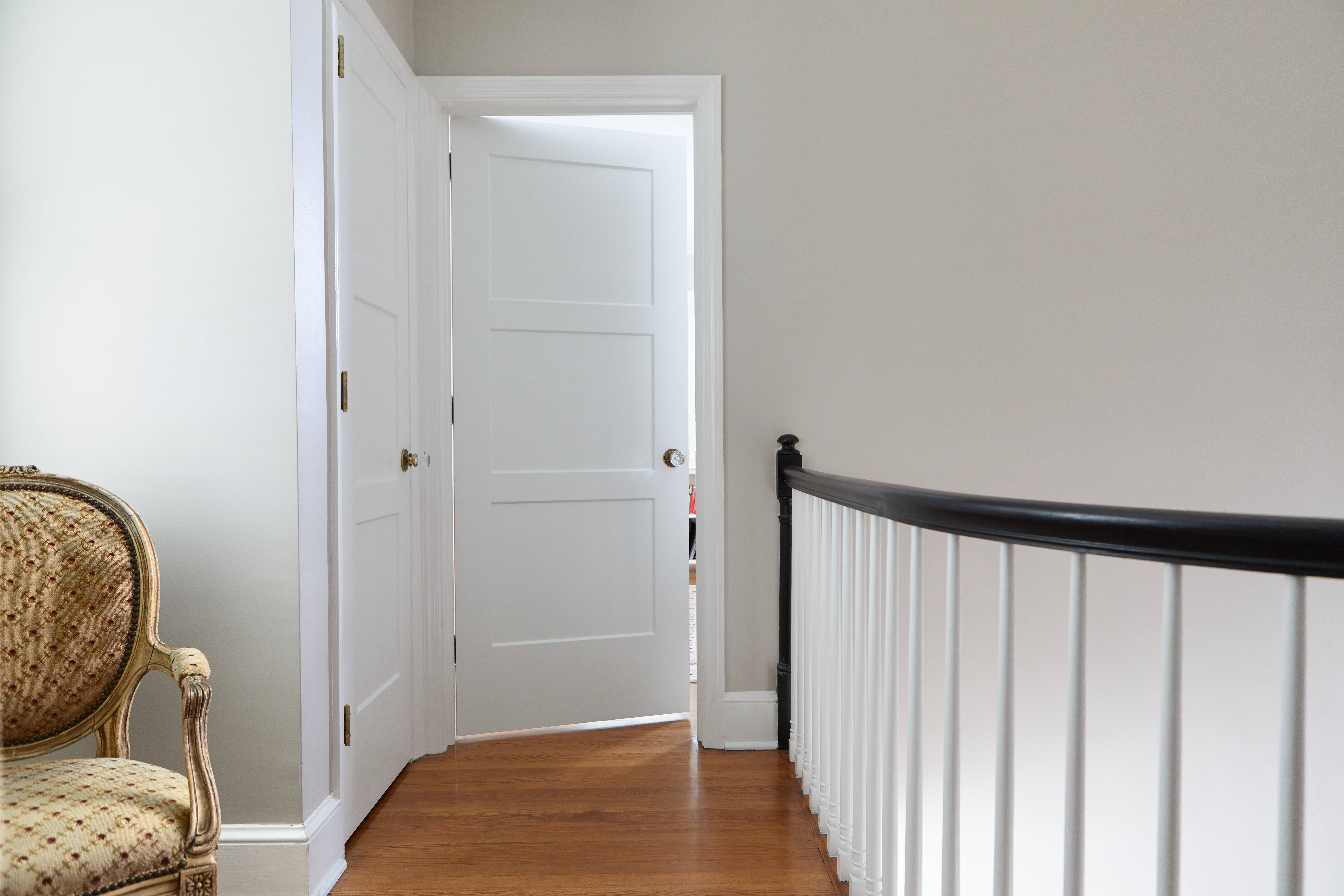 Hallway with white Chelsea shaker doors and wooden flooring